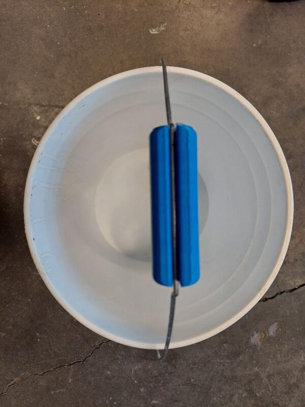 A white bowl with two blue handles on top of it.