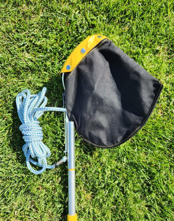 A black bag with yellow trim and blue rope on the ground.