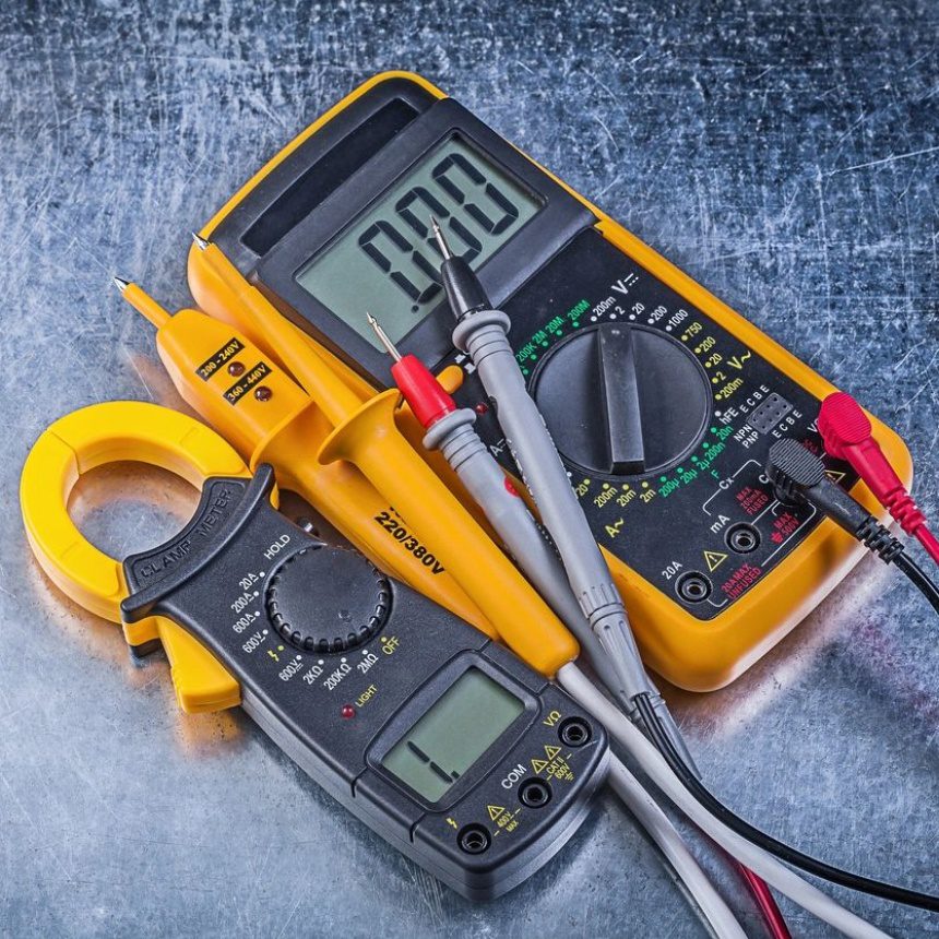 A pair of multimeters sitting on top of a table.