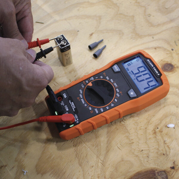 A person is testing the voltage of an electrical device.