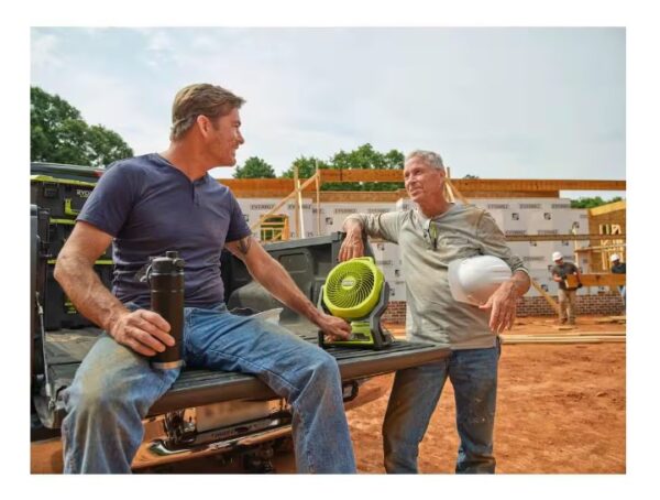 Two men sitting at a picnic table with a frisbee.