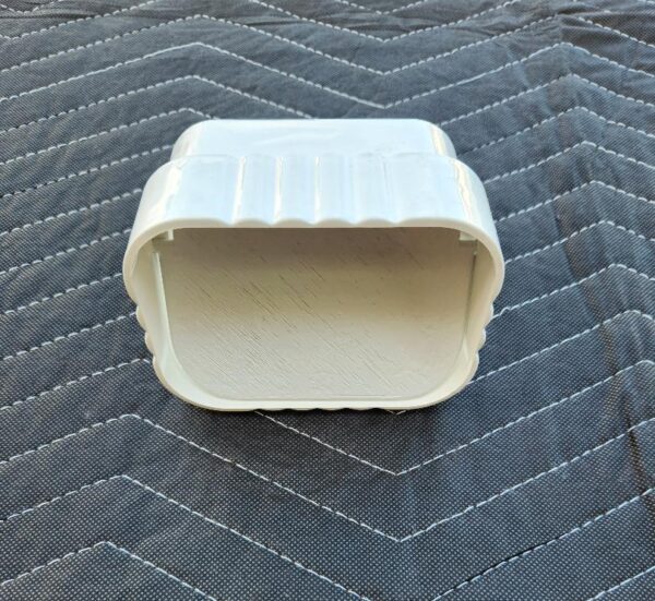 A white container sitting on top of a bed.